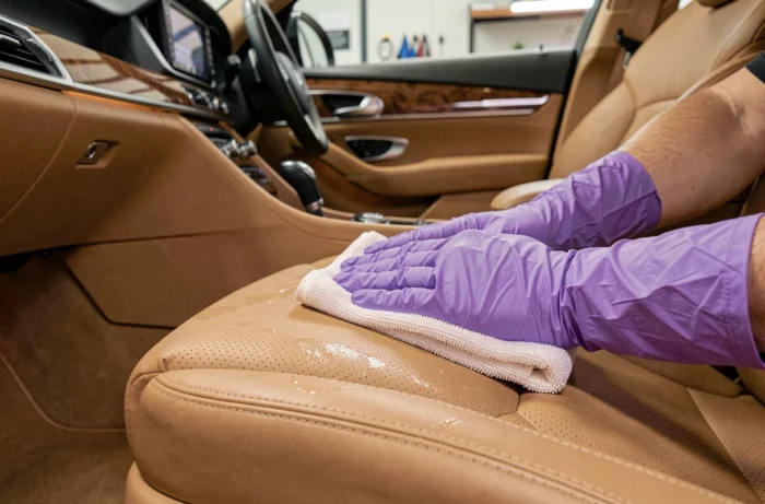 Nettoyage et conditionnement professionnel de sièges en cuir à l'intérieur d'un véhicule haut de gamme par un spécialiste Prostyling
